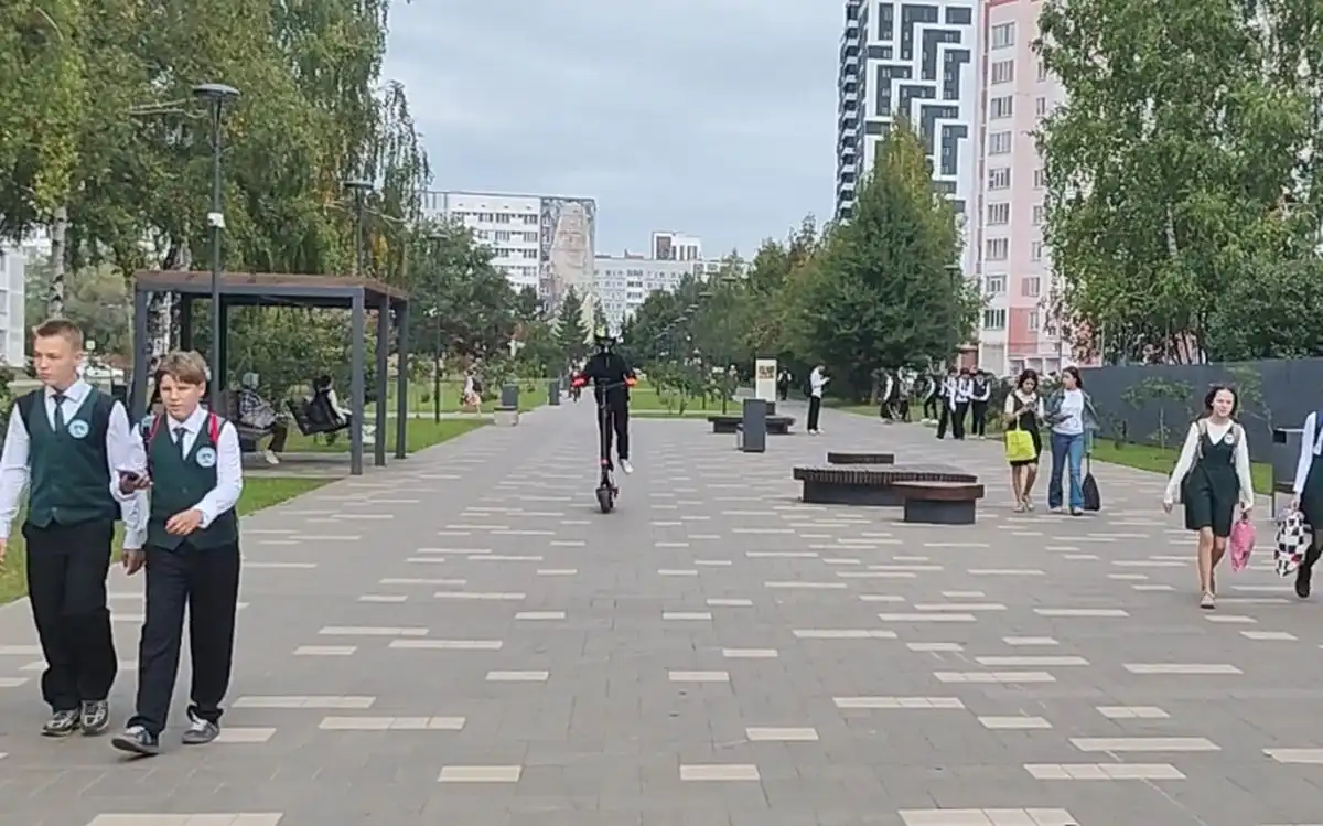 парень на электросамокате несёт по бульвару как бешеный