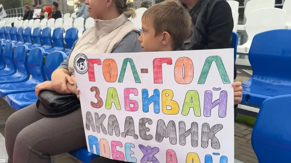 мальчик-болельщик с плакатом на матче ФК Академик
