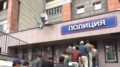 задержанные нелегальные мигранты заходят в отдел полиции