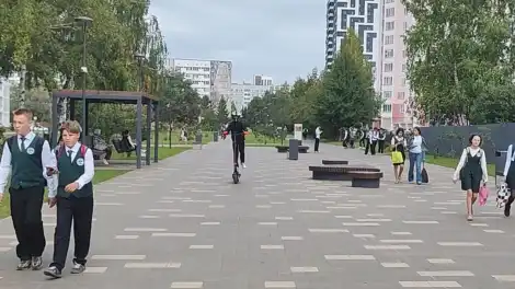 парень на электросамокате несёт по бульвару как бешеный