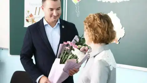 Вице-премьер РТ Ринат Садыков вручает цветы учителю луганской школы