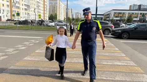 инспектор дпс помогает школьнице перейти дорогу