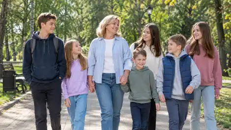 Мать и шестеро детей гуляют по парку