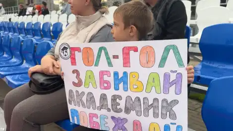 мальчик-болельщик с плакатом на матче ФК Академик