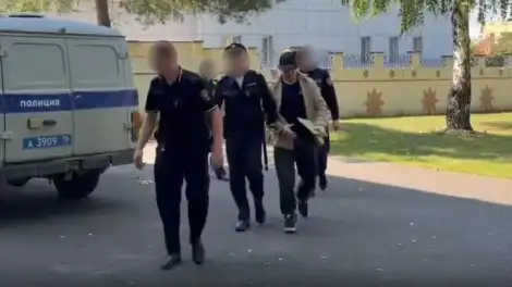сотрудники полиции ведут в зал суда мужчину в наручниках
