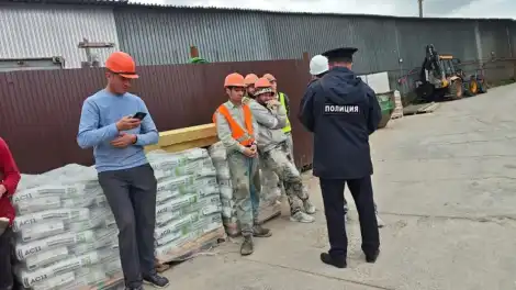 полицейские на стройплощадке и рабочие