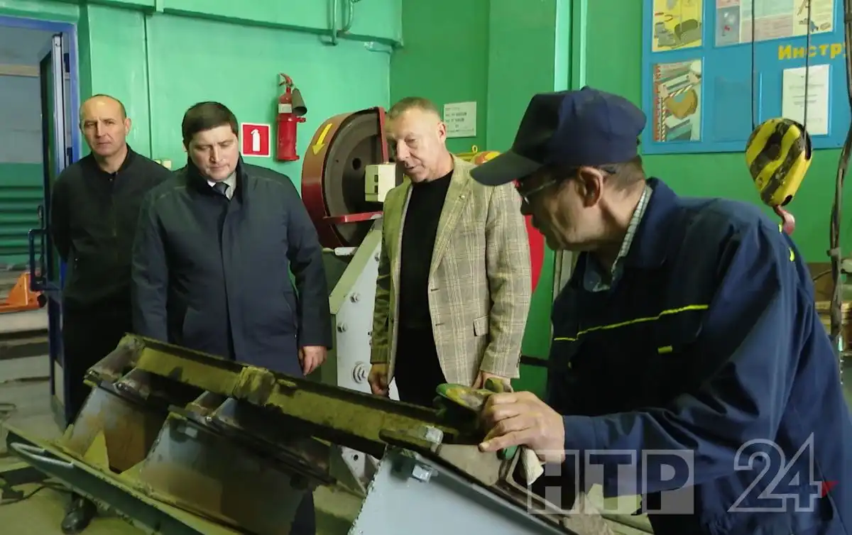 рабочий показывает Радмиру Беляеву устройство
