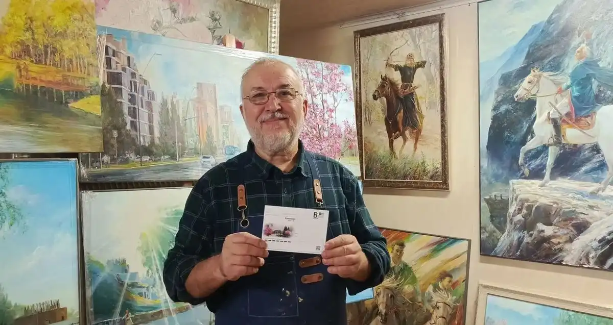 художник Ильдус Муртазин держит открытку к 60-летию Нижнекамска