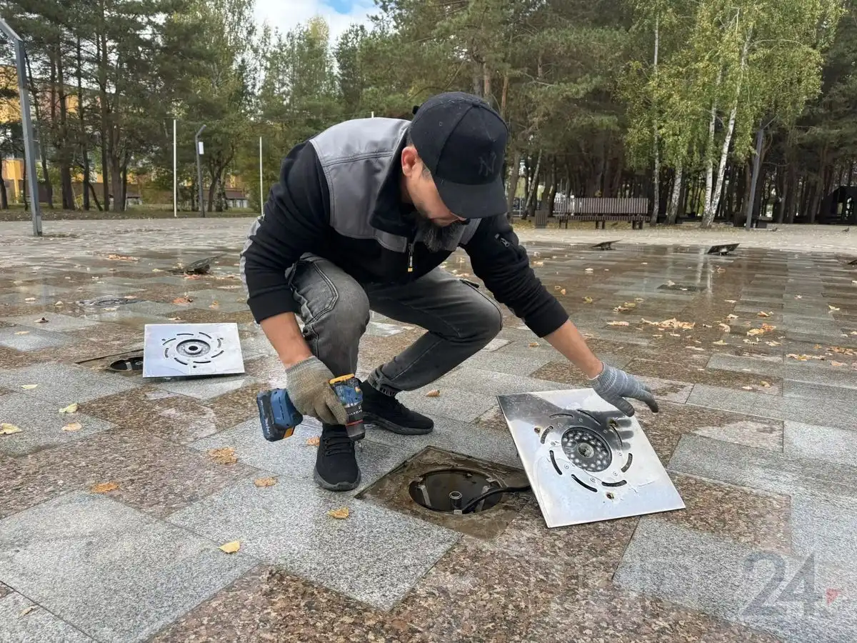 рабочий разбирает форсунку  фонтана