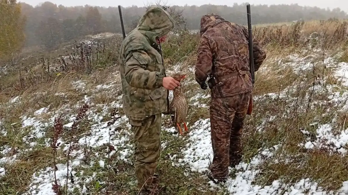 охотник в поле стоит с добычей