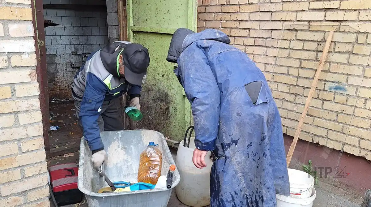 Рабочие чистят мусоропровод