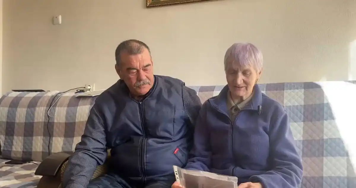 Супруги Макаровы сидят на диване перед телевизором и поют