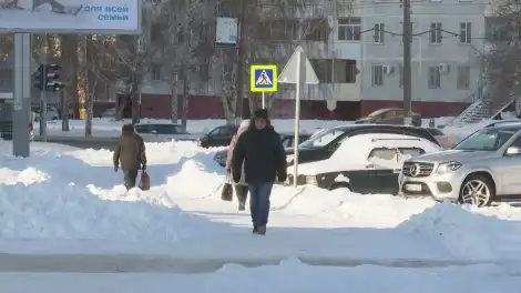 пенсионер идет по улице в Нижнекамске зимой