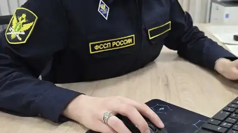 судебный пристав сидит за компьютером