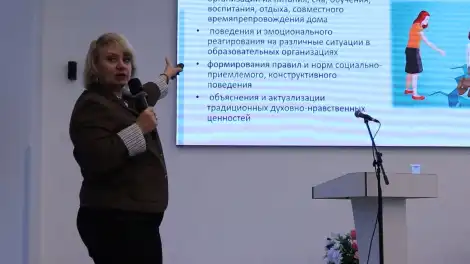 женщина показывает на экран