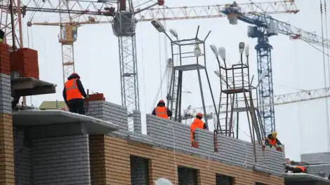 строители на стройплощадке дома