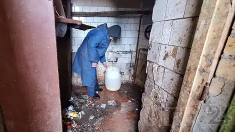 коммунальный рабочий стоит в мусорной камере