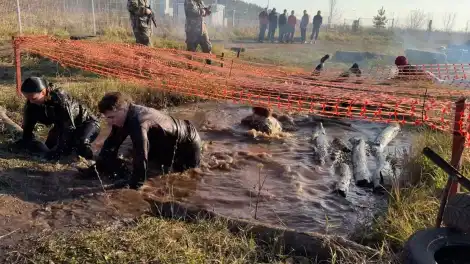 студенты ползут по грязи и воде