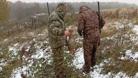 охотник в поле стоит с добычей